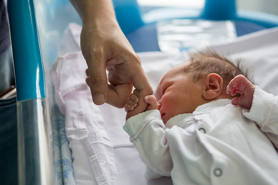 Beautiful newborn baby boy, laying in crib in prenatal hospital