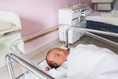 A newborn baby sleeping in a baby at the hospital protected by the Cuddles Infant Protection System