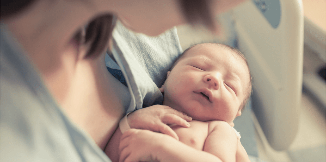 New mother holding newborn baby in a safe and secure hospital